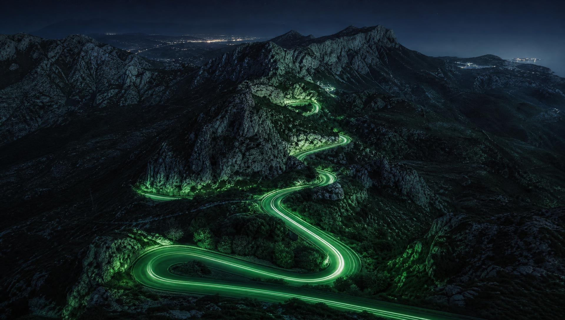 Route de col sinueuse illuminée dans les montagnes de la Côte d'Azur de nuit